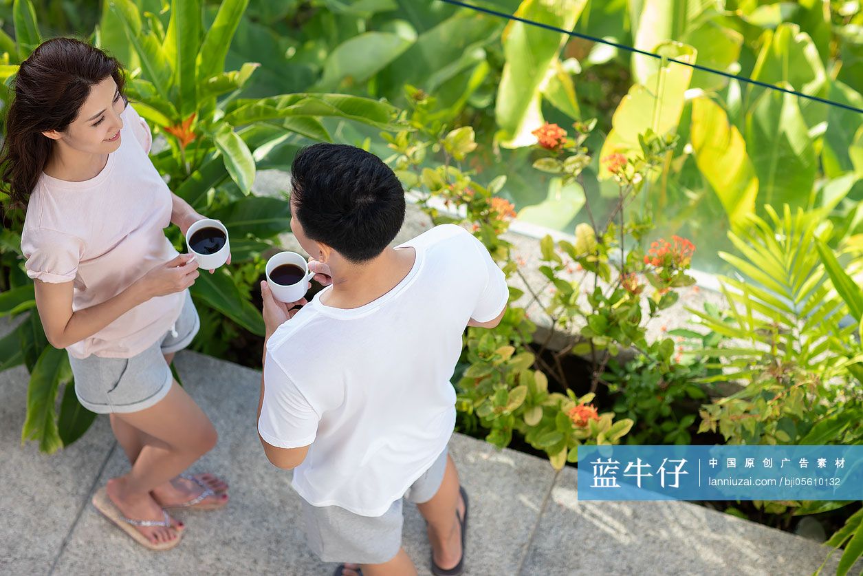 快乐的年轻夫妇在阳台喝咖啡