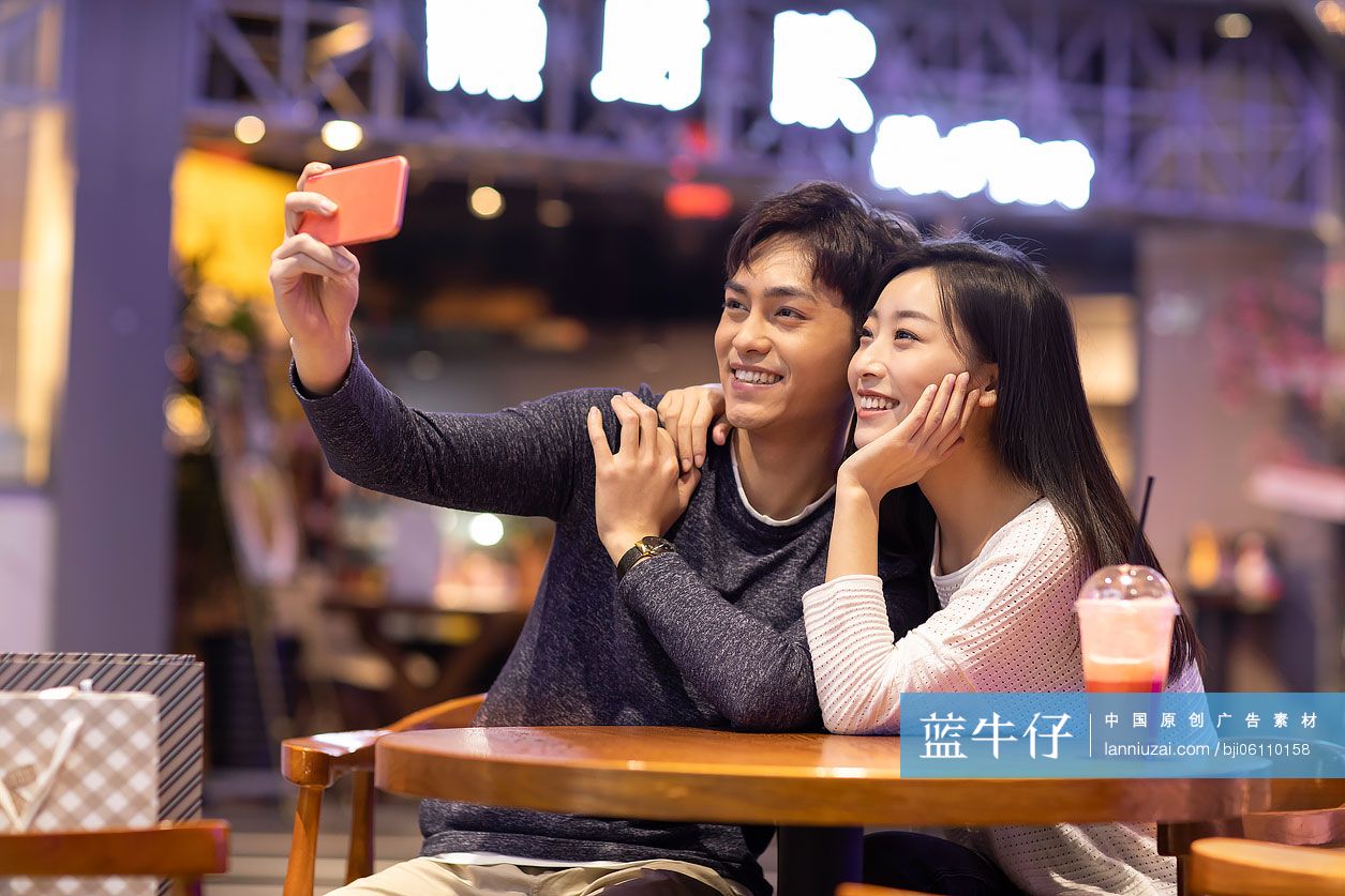 快乐的年轻情侣在商场自拍