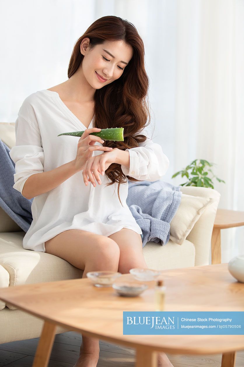 Young Chinese woman with natural aloe vera at home