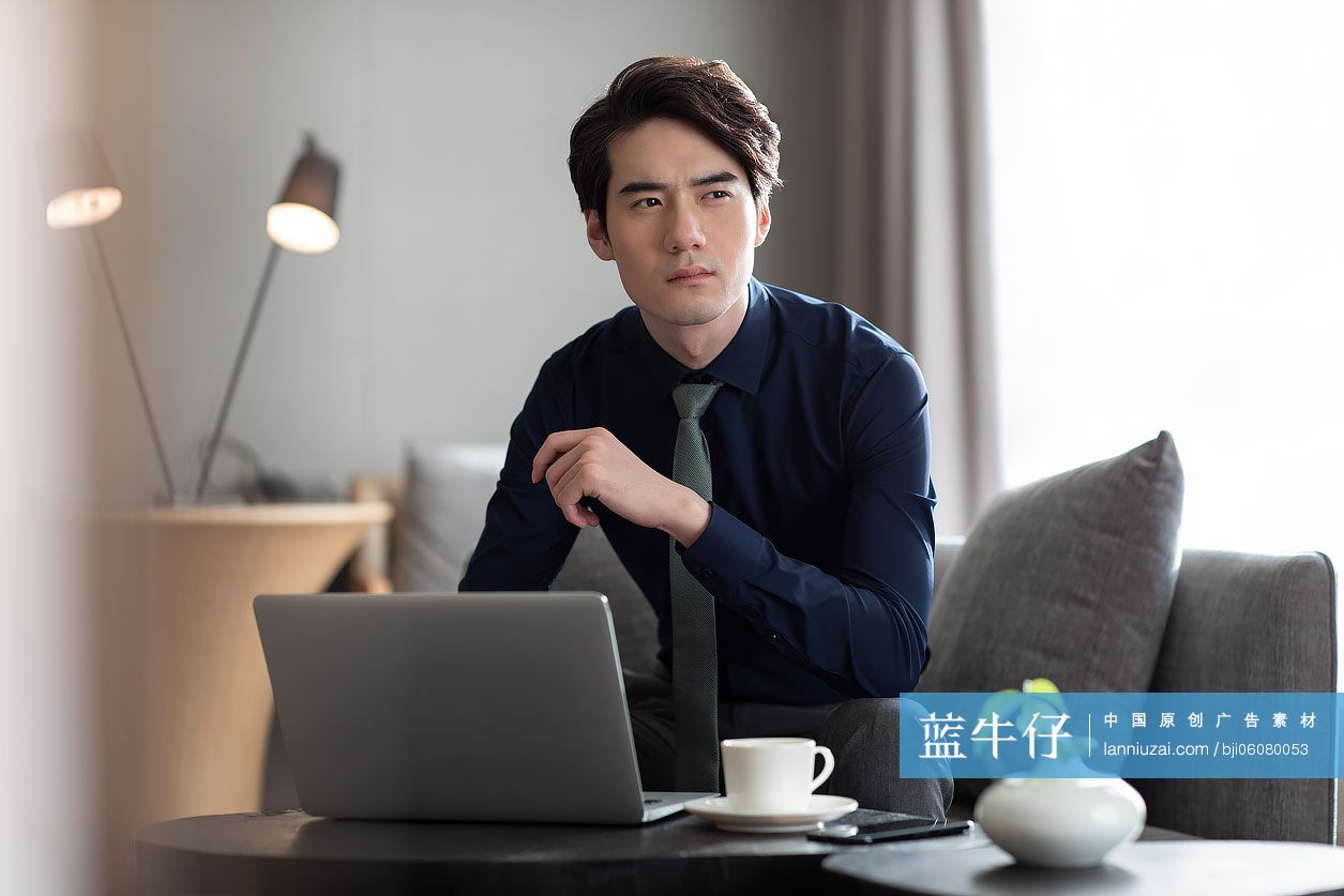 年轻商务男士在酒店使用笔记本电脑