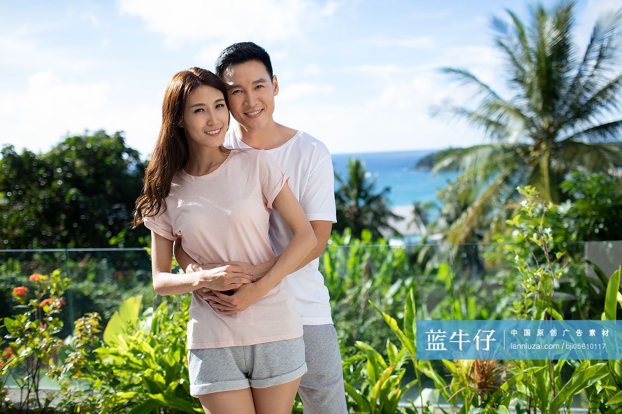 快乐的年轻夫妇在阳台拥抱