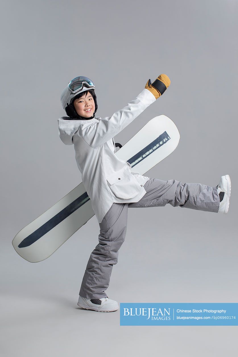 Cheerful Chinese boy with snowboard