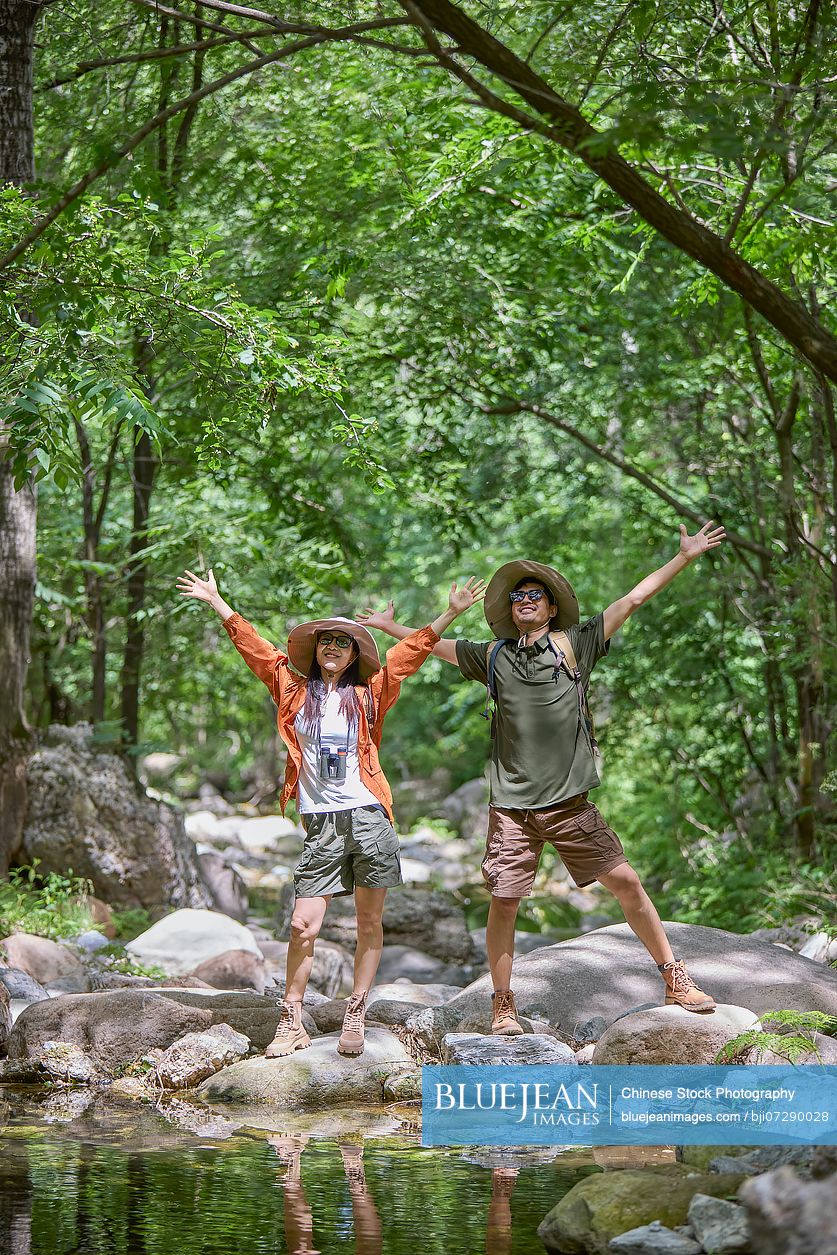 Happy couple hiking up a mountain, enjoying the fresh air