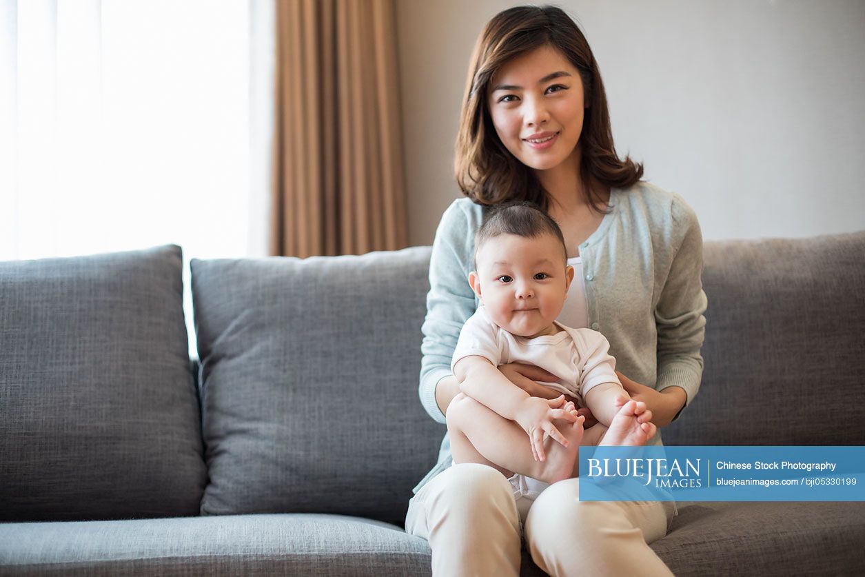 Happy Chinese mother and cute baby at home