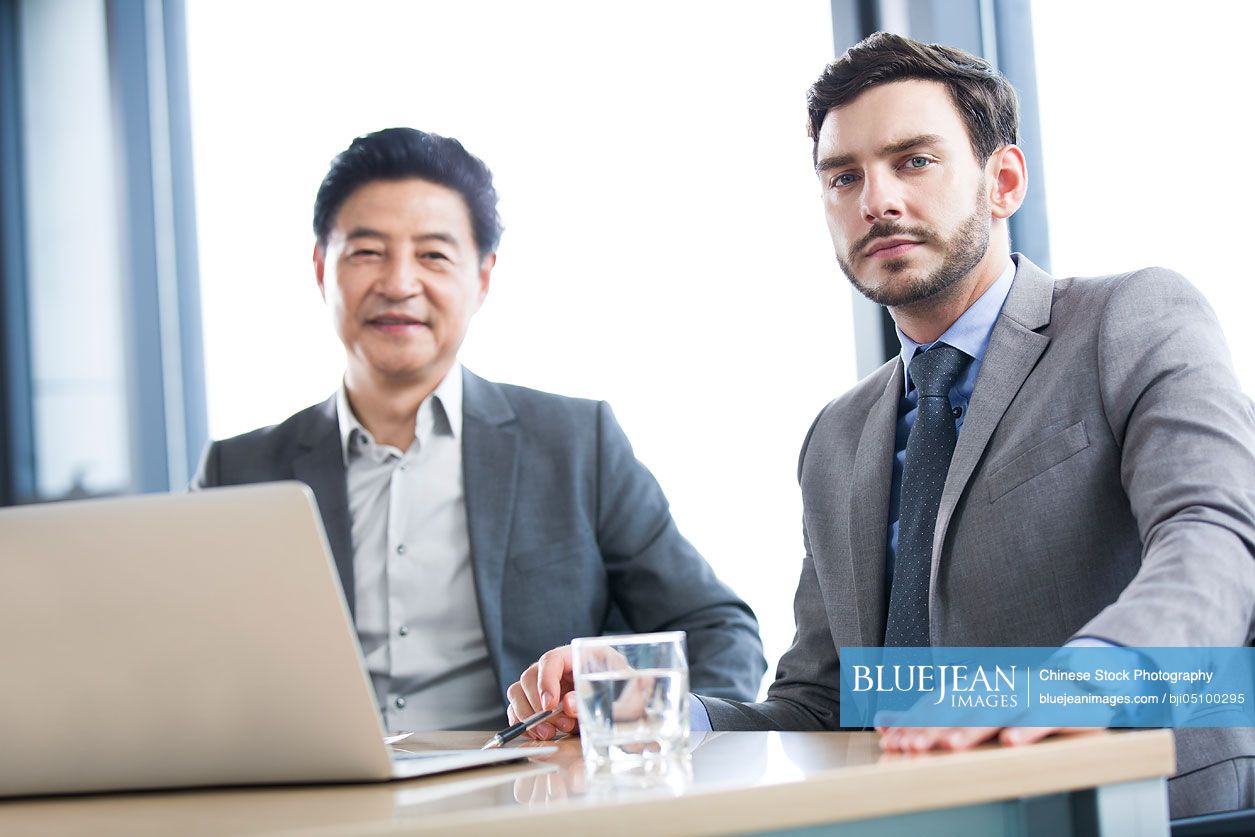 Chinese business people talking in meeting room