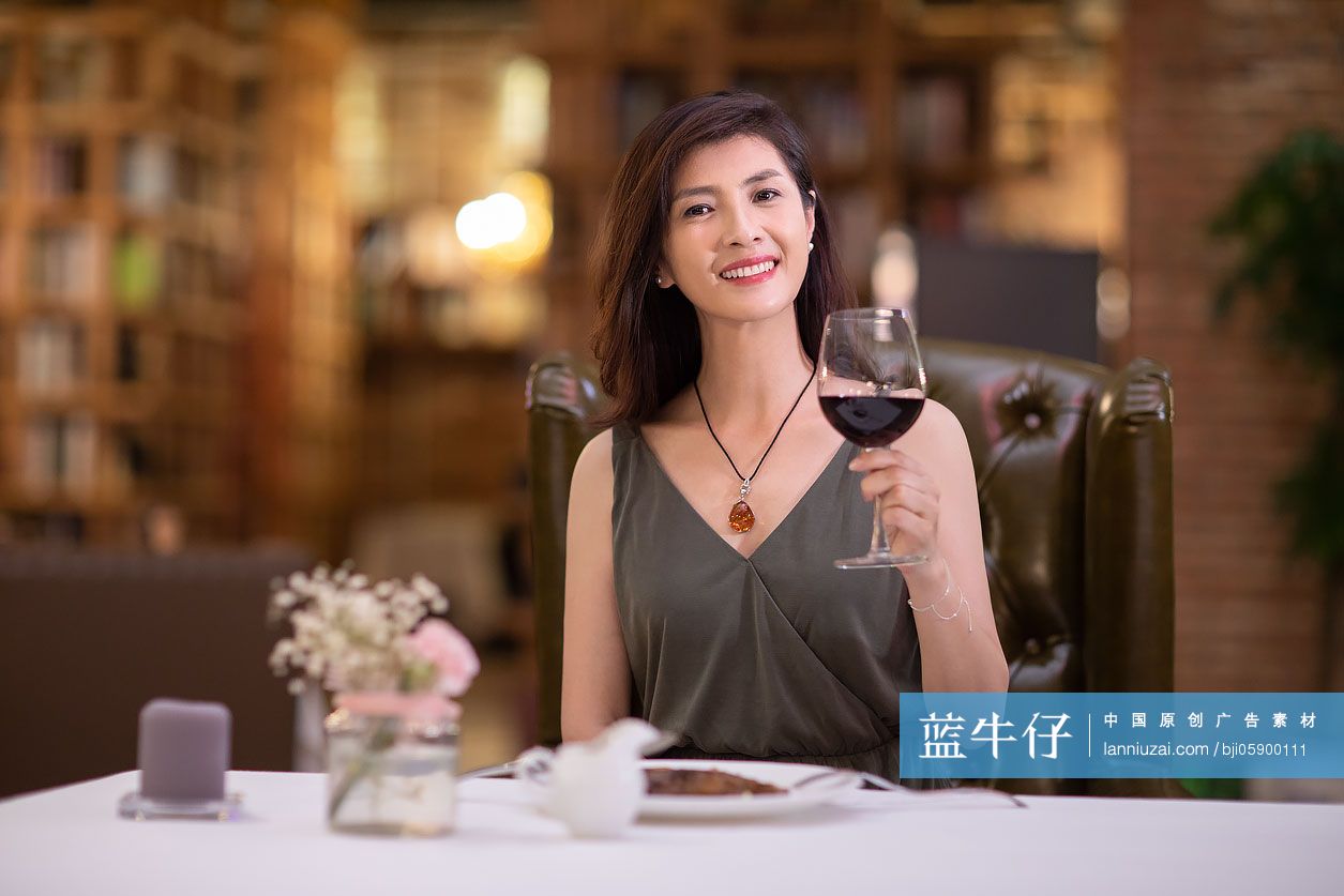 优雅女士在餐厅品尝红酒