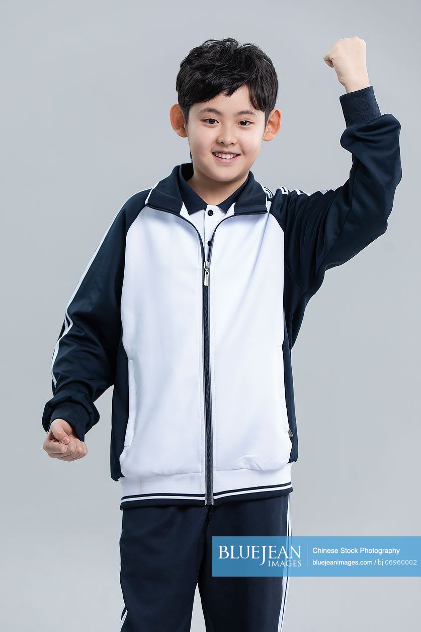 Studio shot of cheerful Chinese student cheering
