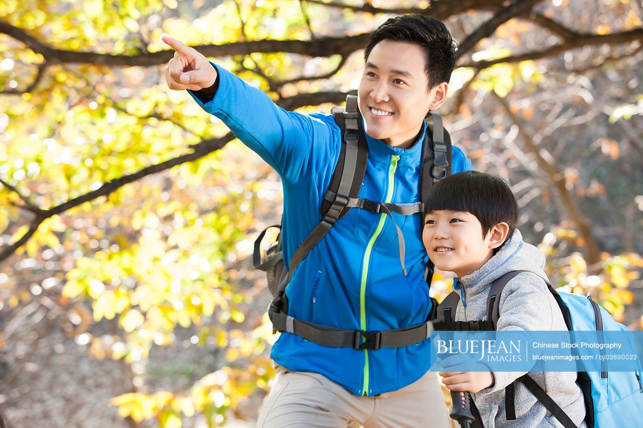 Cheerful Chinese father and son hiking