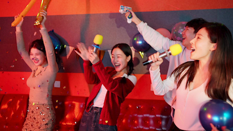 Young friends having fun at birthday karaoke party