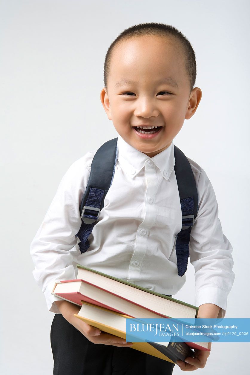 Young Chinese boy carries books