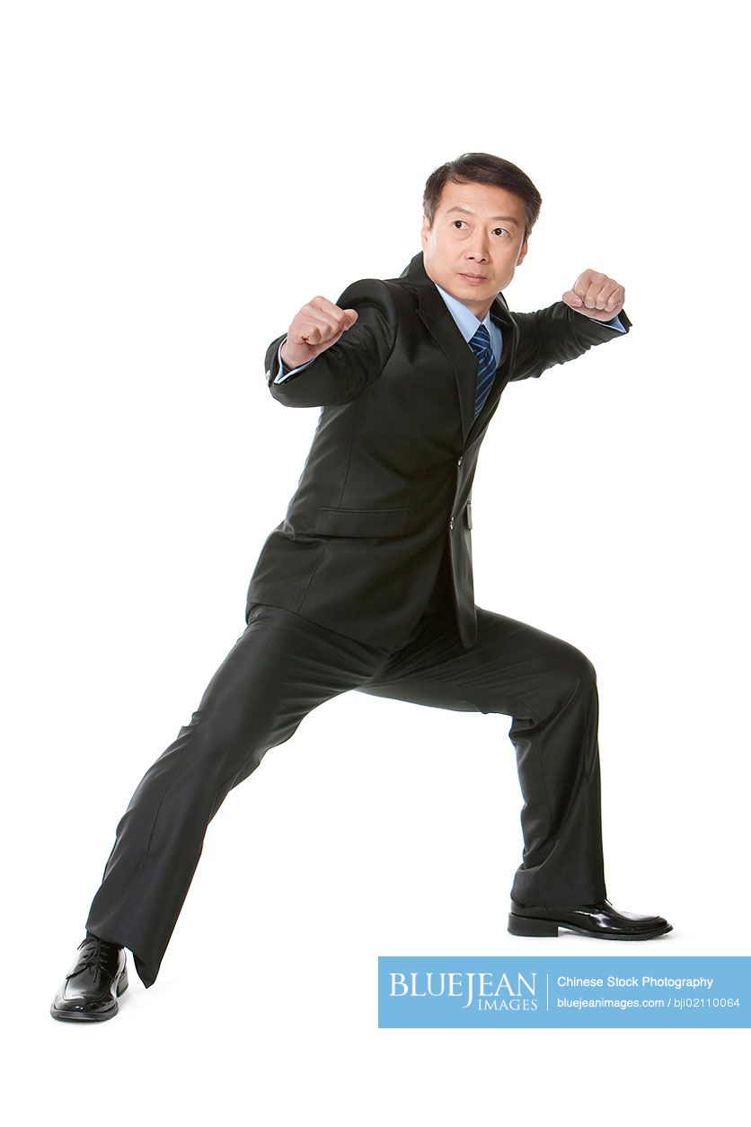 Mature Chinese businessman in martial arts fighting stance