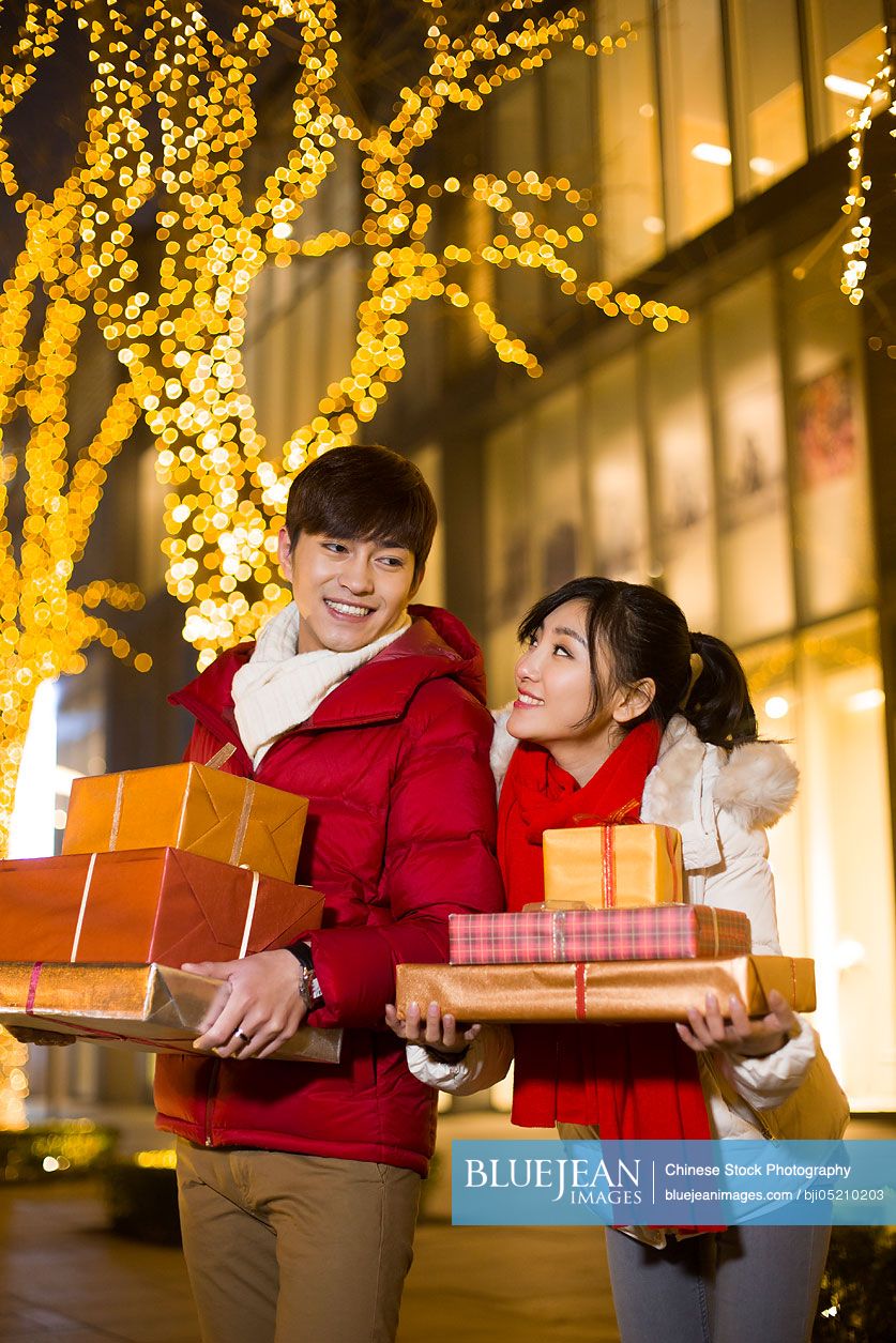 Happy young Chinese couple with new year gifts