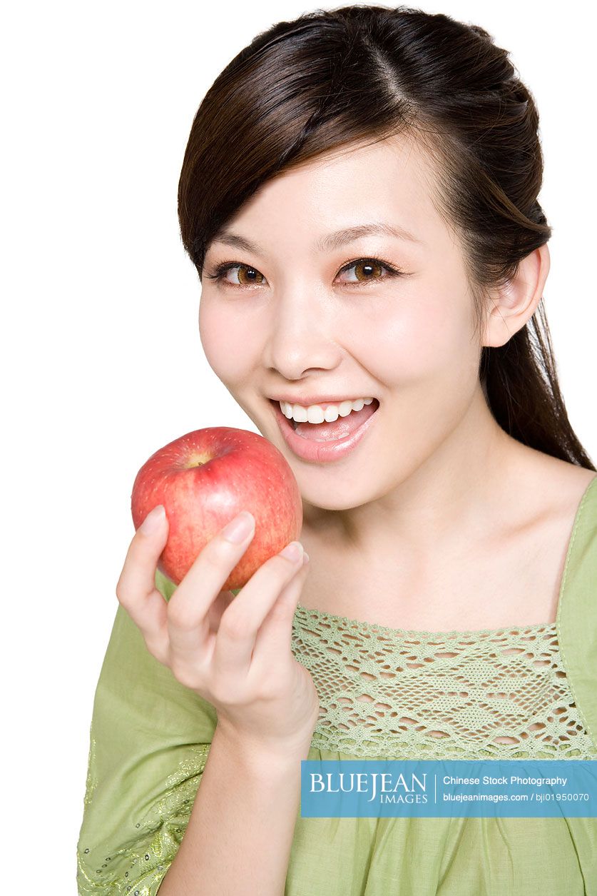 Portrait of young Chinese woman with red apple