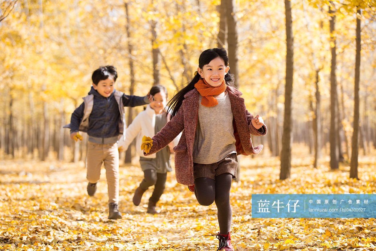 三个小孩在秋日的树林里奔跑