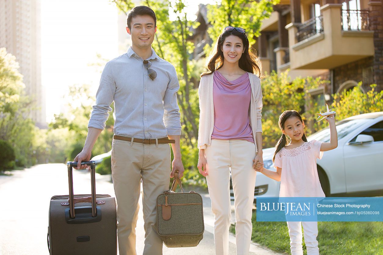 Happy young Chinese family going for vacation