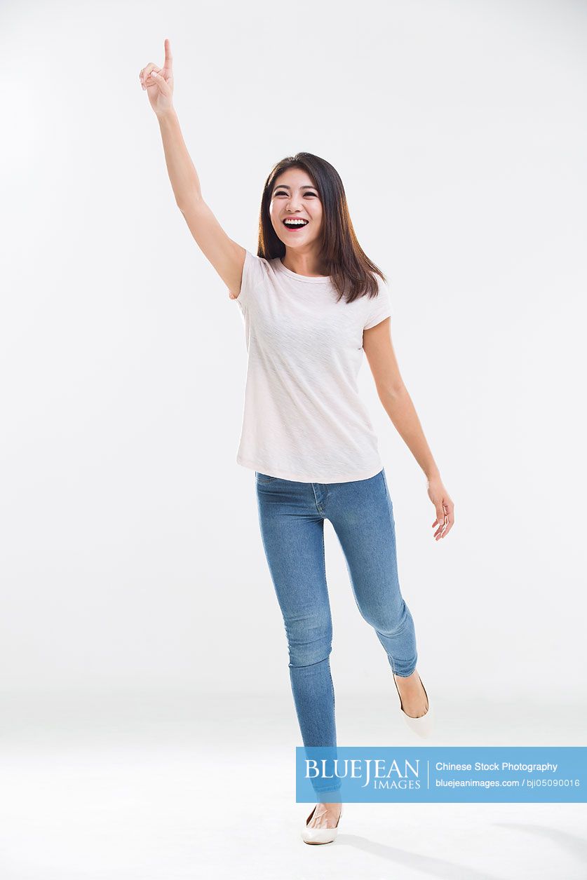 Cheerful young Chinese woman pointing