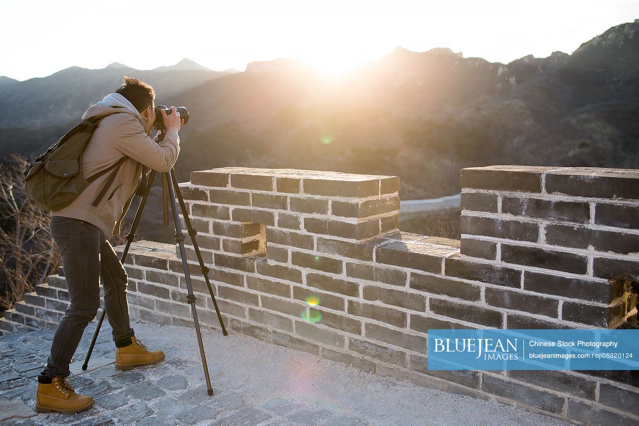 Young Chinese man photographing on the Great Wall