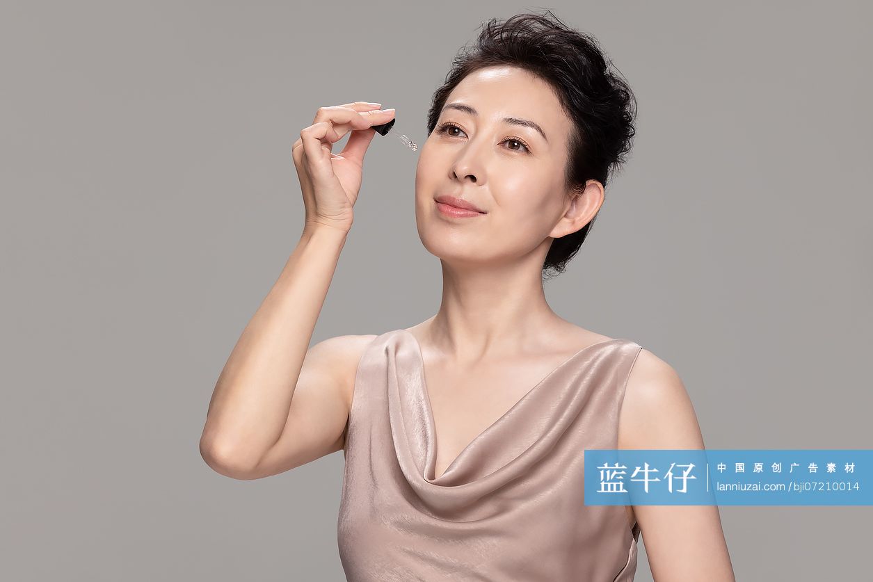 美丽的女性使用精华液