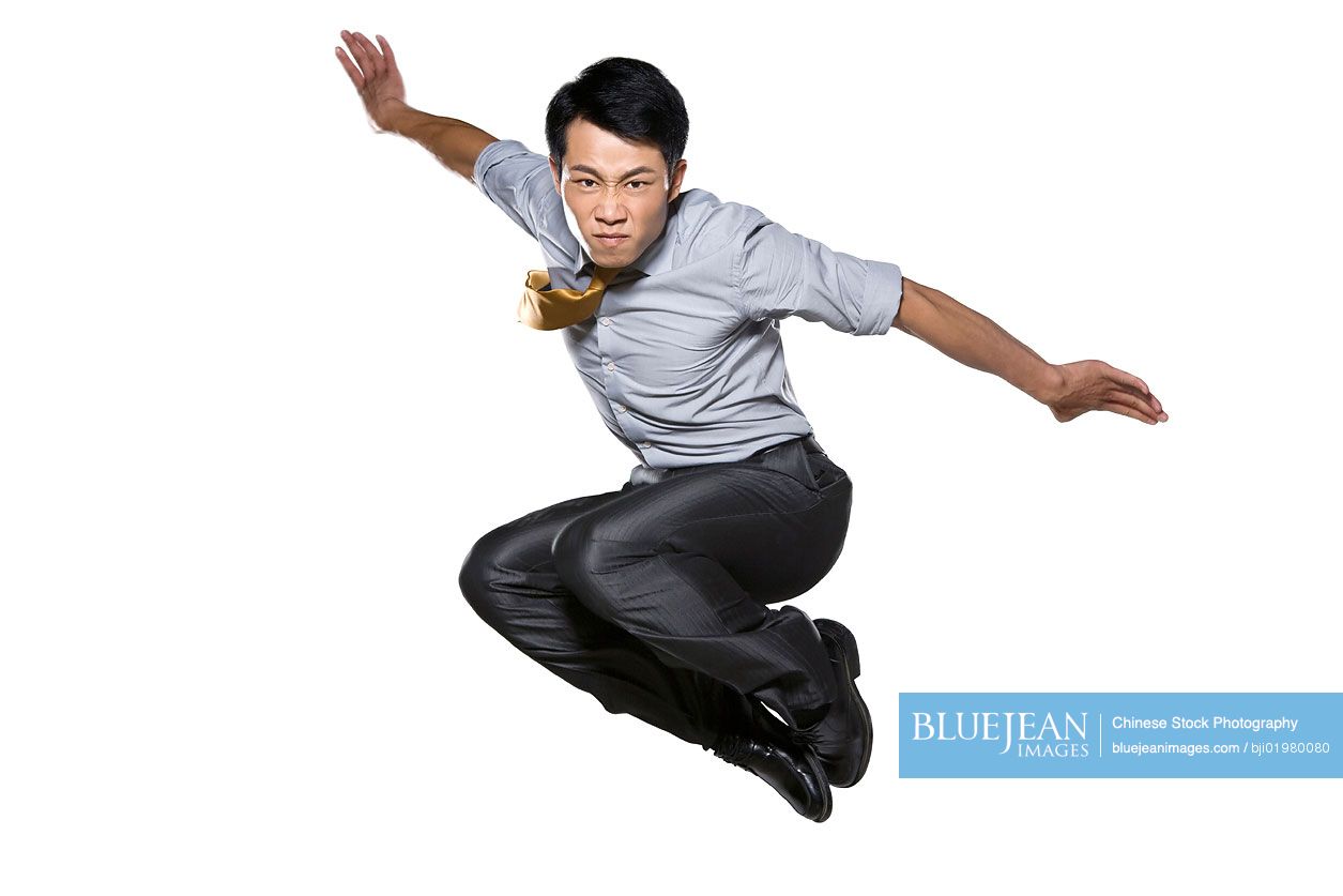 Chinese businessman jumping in mid air