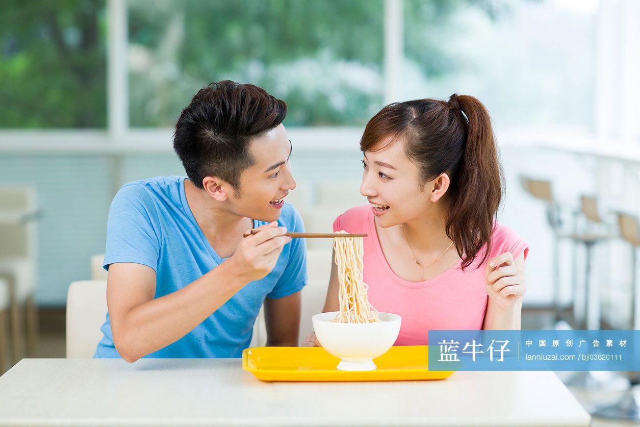年轻情侣在餐厅吃面