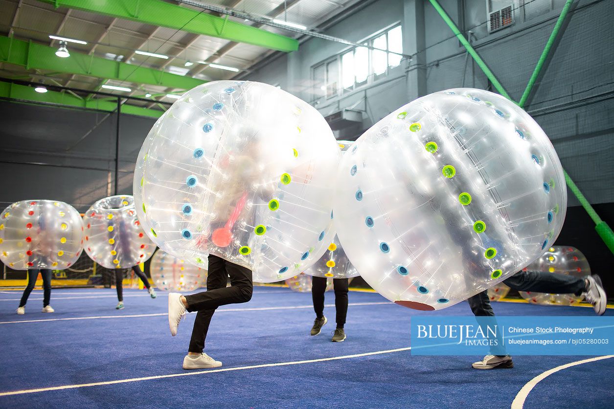 Young Chinese friends playing with bumper balls
