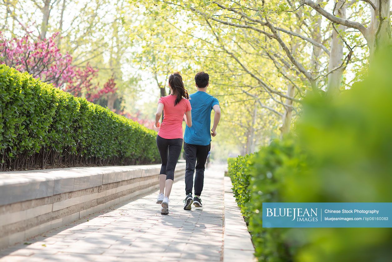 Young Chinese couple running in park