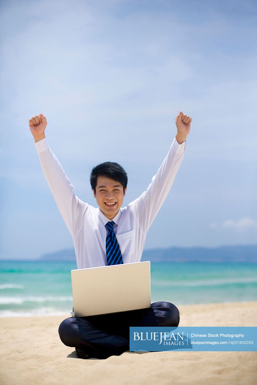 Chinese businessman working at the beach