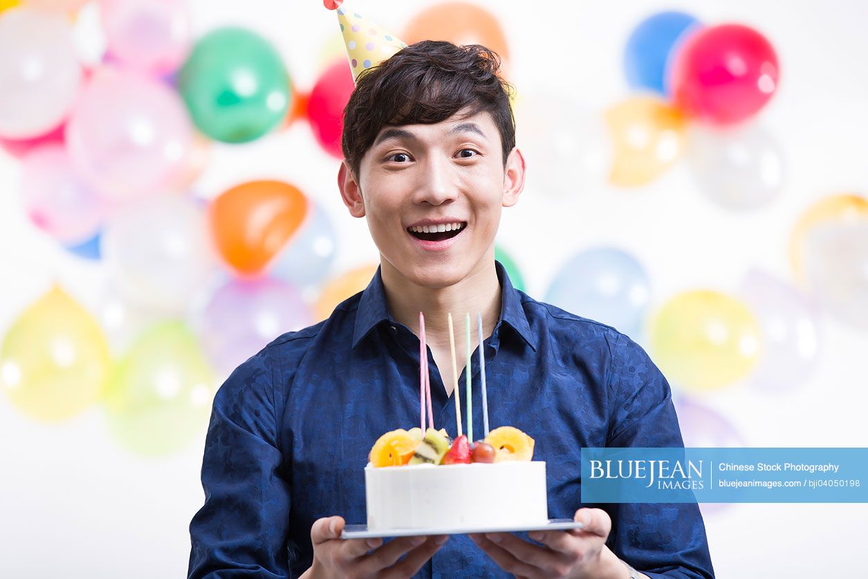 Young Chinese man with birthday cake