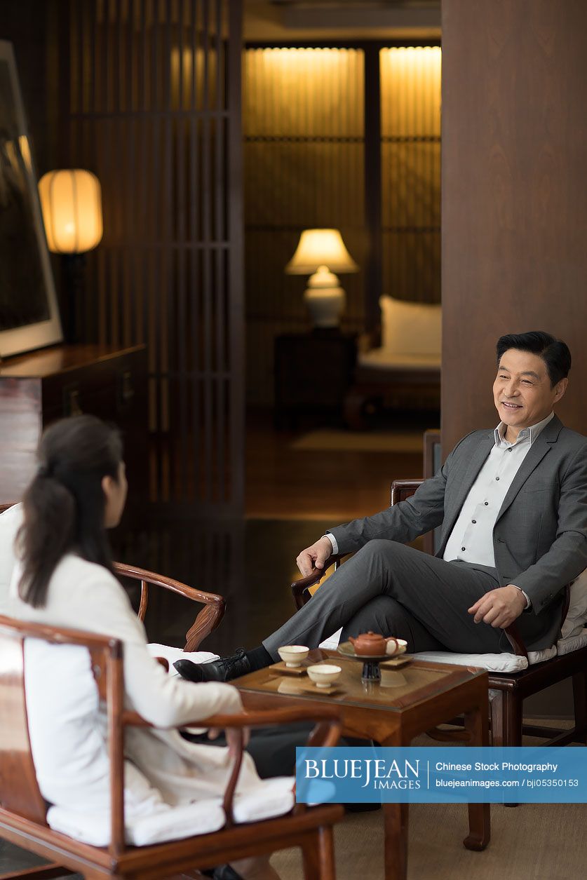 Cheerful Chinese businessman talking with a woman