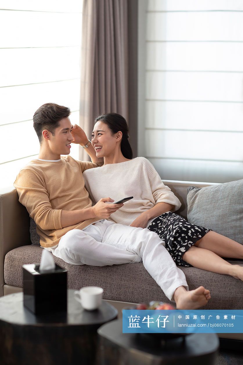 快乐的年轻情侣在客厅沙发上