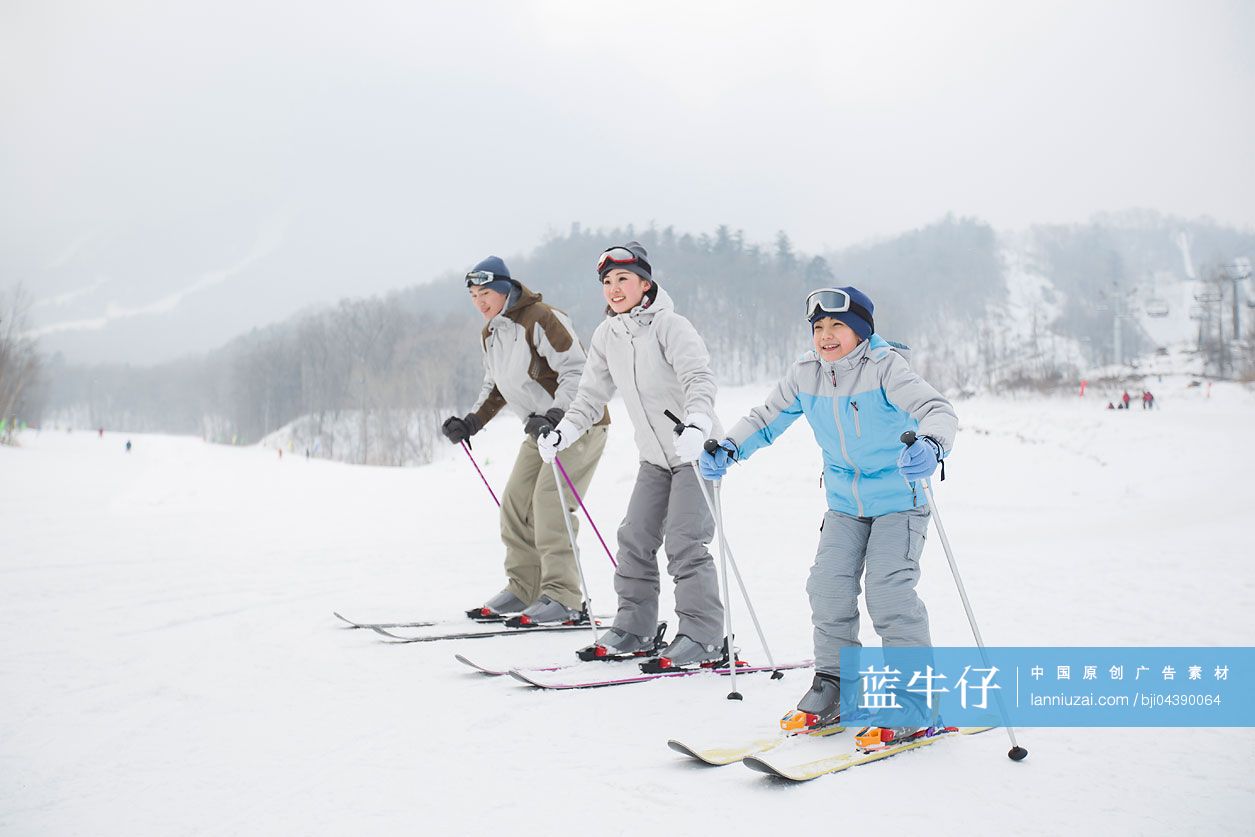 年轻家庭在滑雪场滑雪