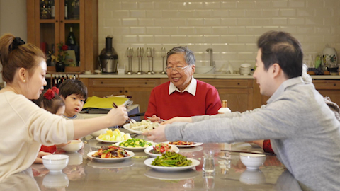 A son gifting his father a fine bottle of spirits to celebrate Chinese New Year