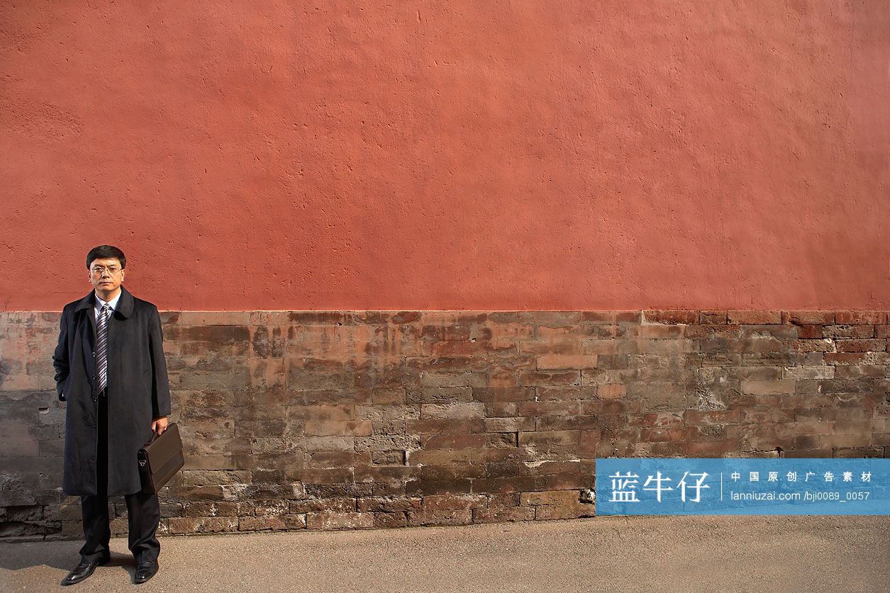 商务男士站在宫墙下