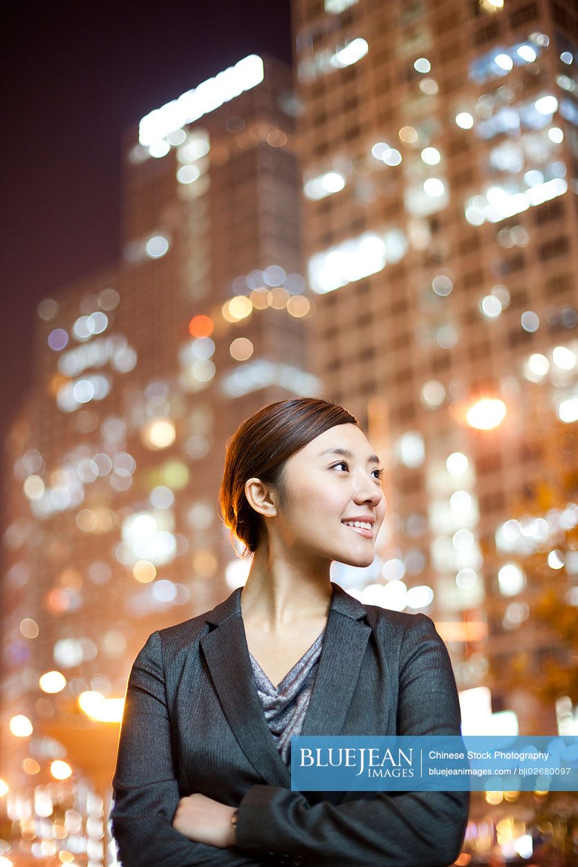 Chinese businesswoman with city lights in the background