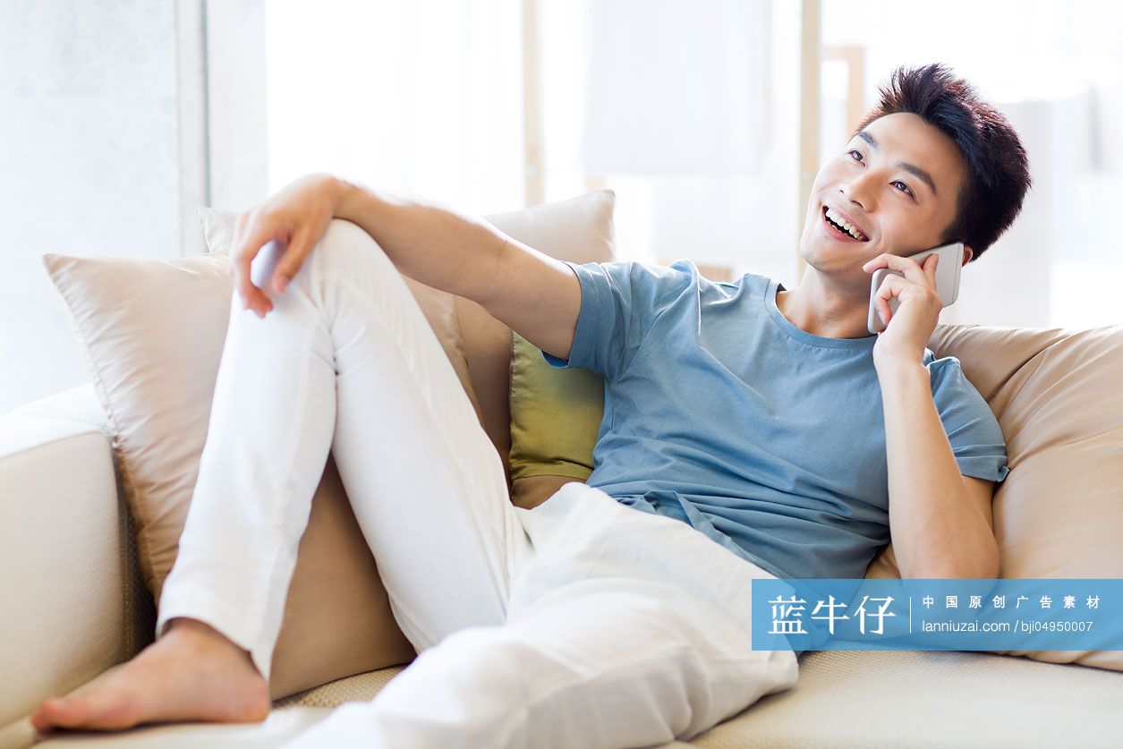 年轻男子在沙发上打电话