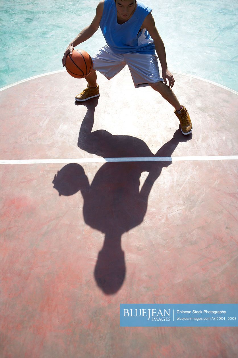 Young Chinese man playing basketball