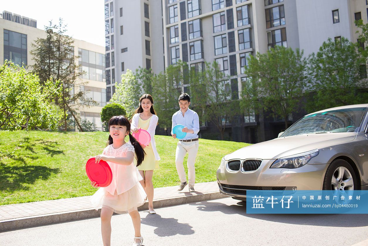 快乐的三口之家玩塑料飞盘