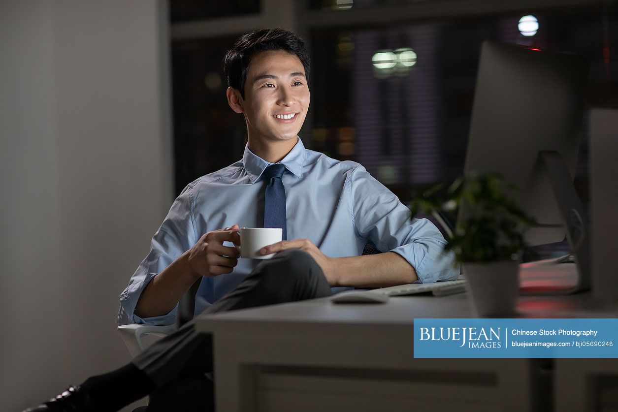 Young Chinese businessman working late in office