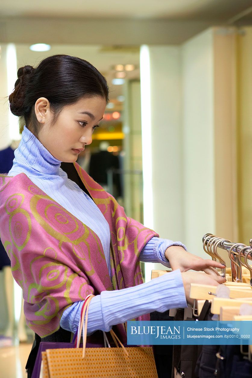 Chinese woman looking at clothes in store