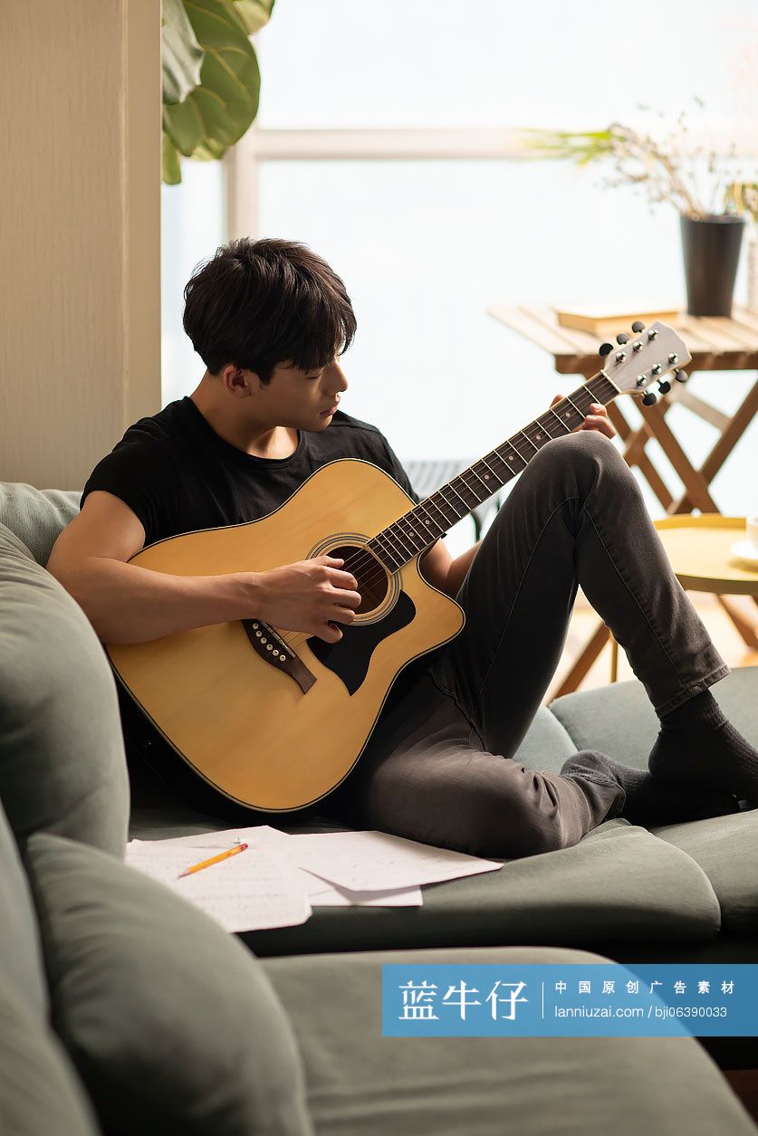 年轻男士在家弹吉他