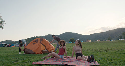 Happy young Chinese friends camping outdoors,4K