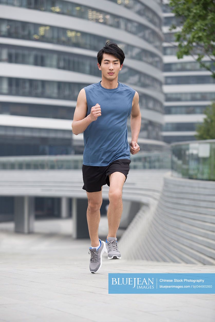 Young Chinese man running outside