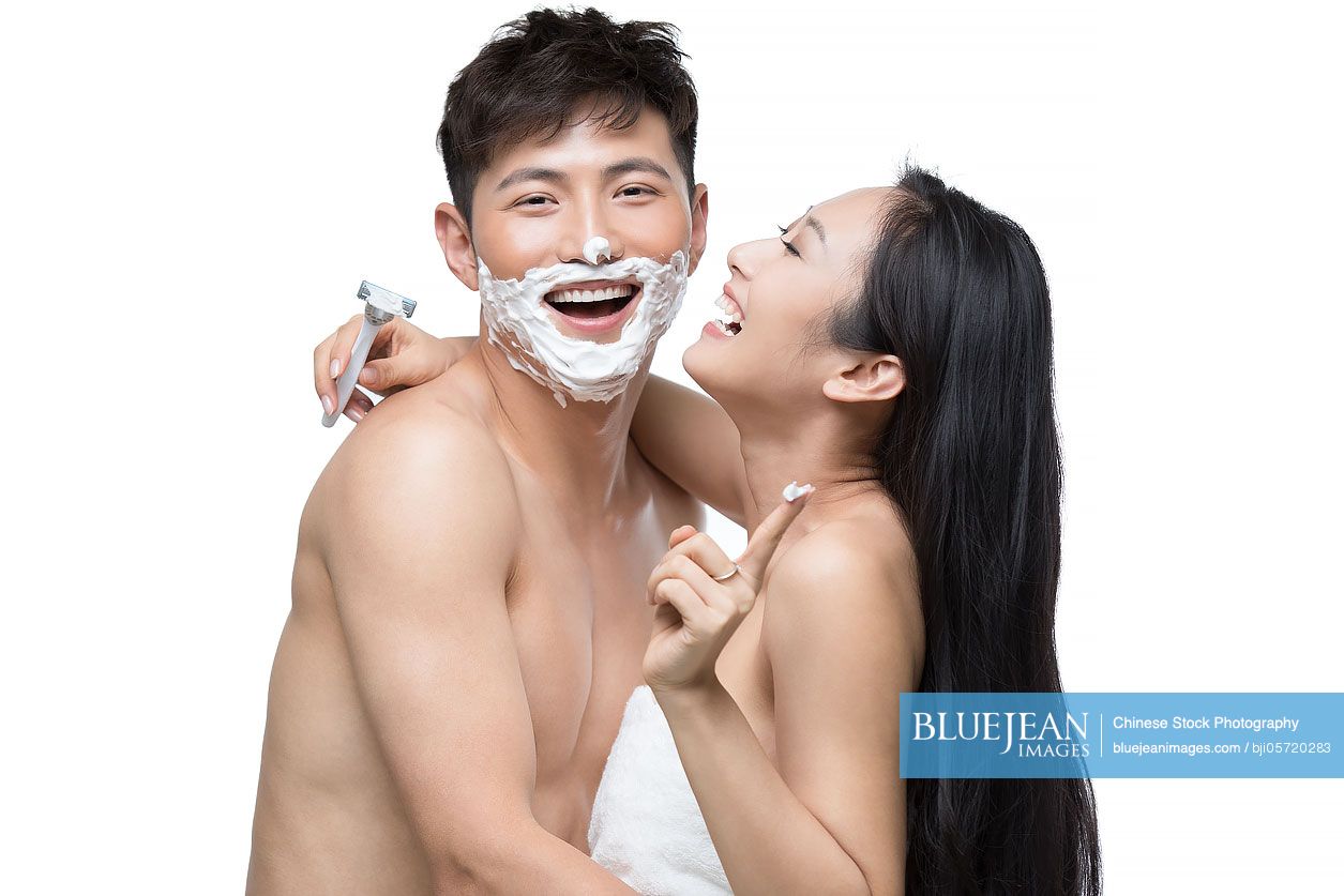 Young Chinese woman shaving her husband