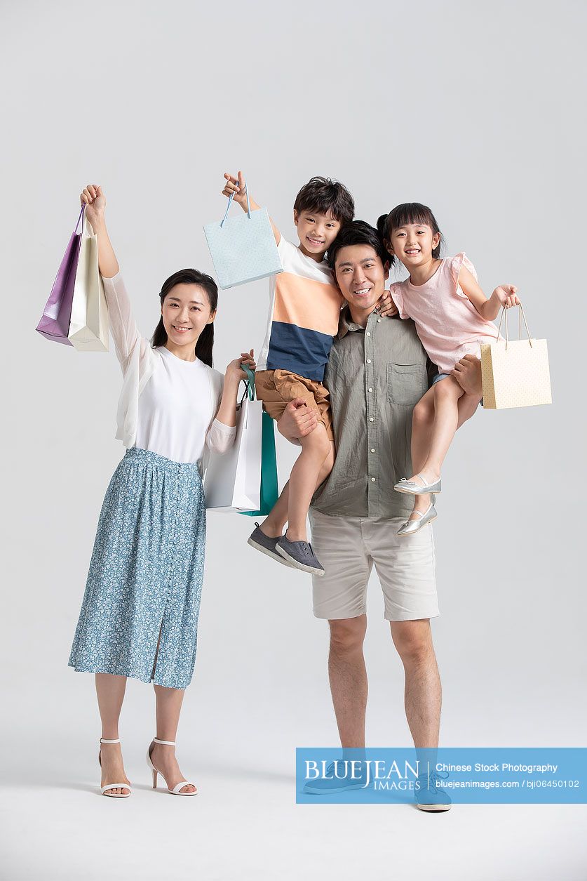 Happy young Chinese family shopping together