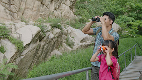Happy young Chinese family using binoculars outdoors,4K