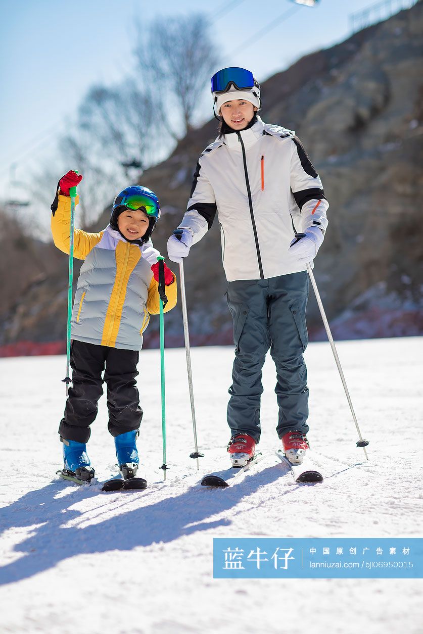 小男孩跟着教练在户外学滑雪