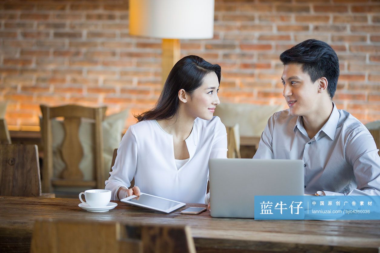 年轻男女在咖啡馆使用笔记本电脑