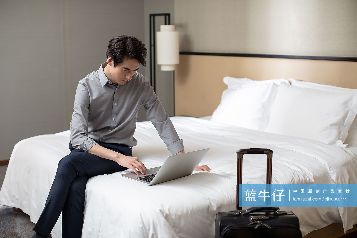 年轻商务男士在酒店房间使用笔记本电脑