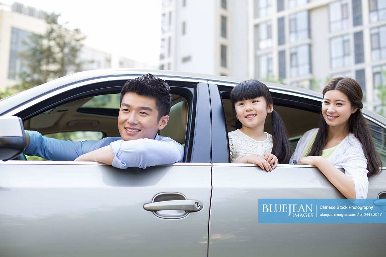 Happy young Chinese family in a car