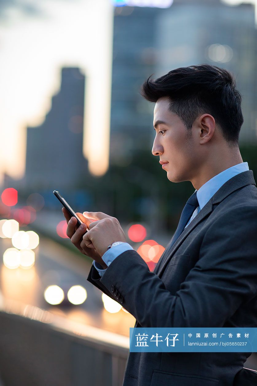 自信的年轻商务男士使用手机